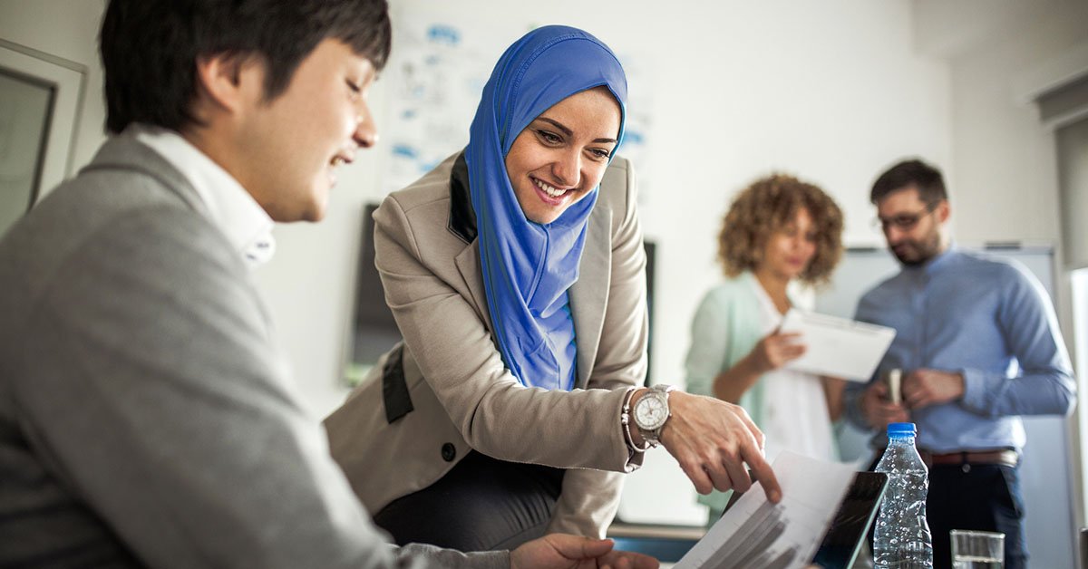 Une équipe diversifiée de professionnels des affaires, dirigée par une femme d'affaires compétente, participe à une réunion de bureau cruciale.