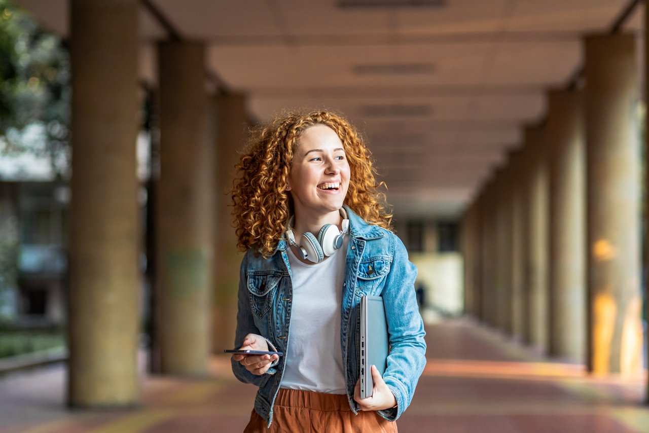 Young woman holding laptop and smart phone