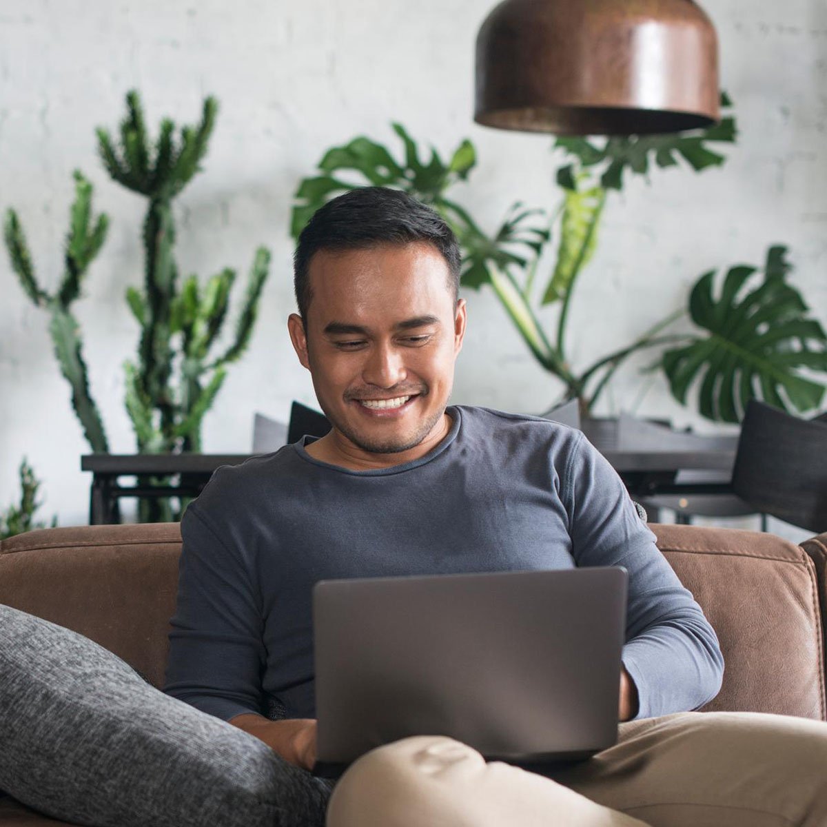 Un homme d'affaires adulte travaille à domicile, utilisant son ordinateur portable pour accéder à Internet pour des tâches professionnelles.