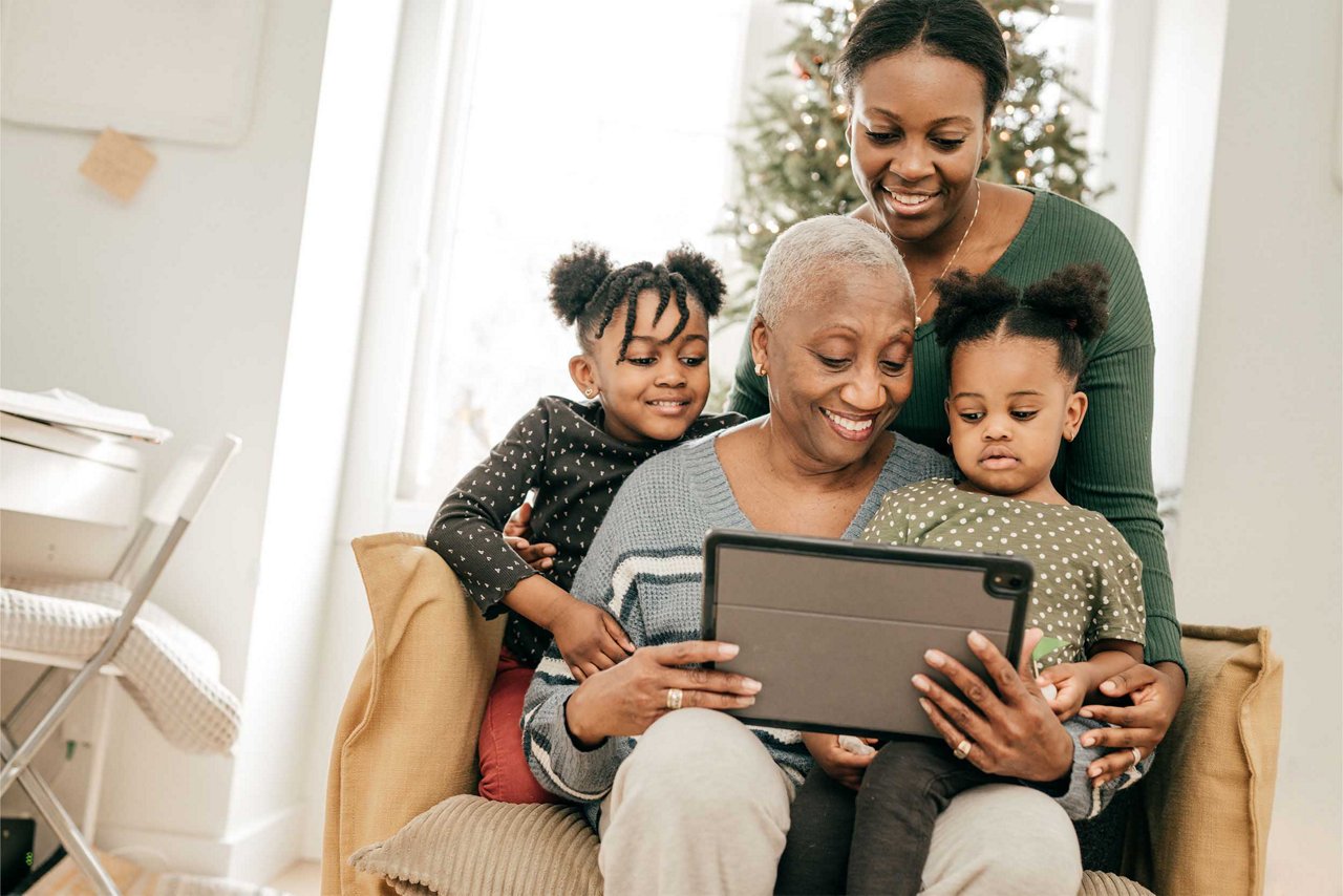 A family smiling and looking at a tablet
