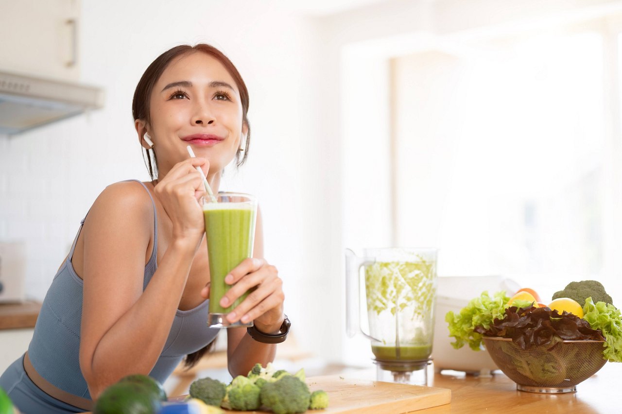Woman enjoying healthy green smoothie at home