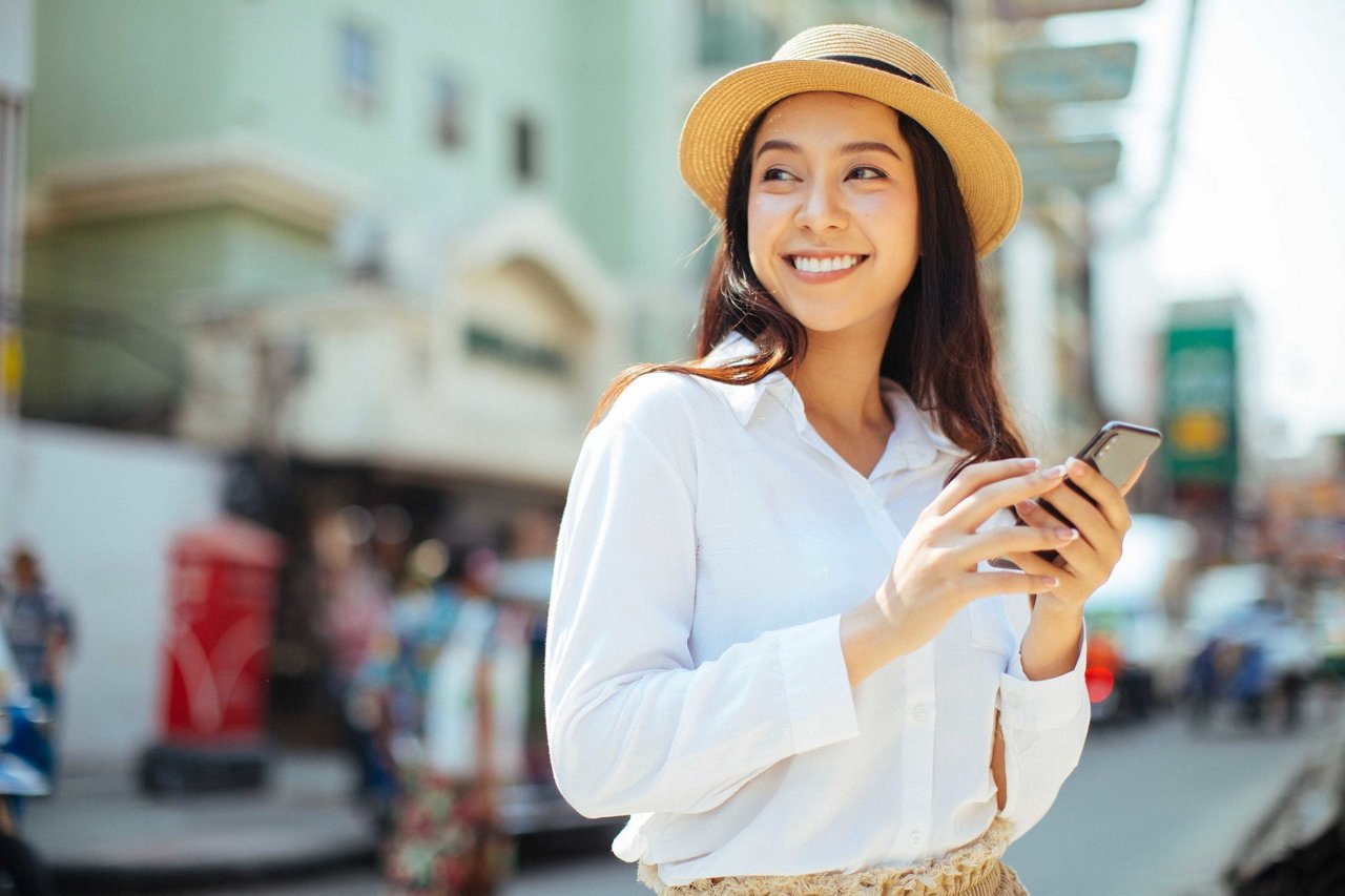 Young stylish woman using phone walking on the street