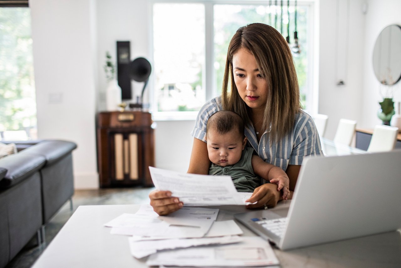 Jeune mère regardant des documents avec bébé sur ses genoux