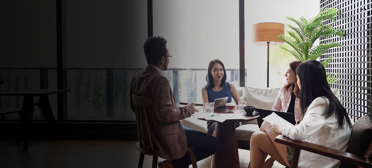 A group of professional businesswomen is engaged in a meeting, discussing critical business matters.