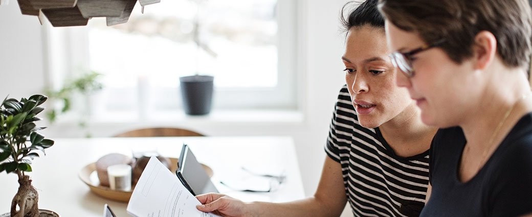 2 women looking at financial documents.