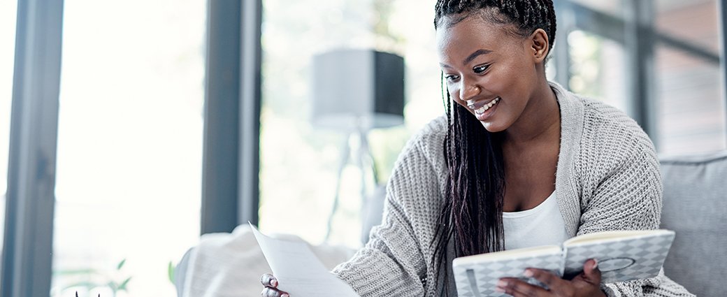 woman smiling while reading a document