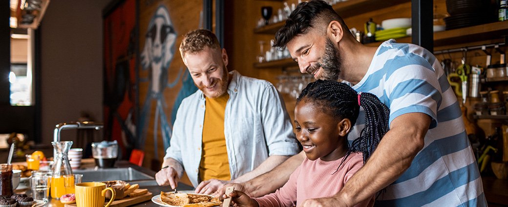 Un portrait de famille joyeux mettant en vedette une femme et un homme souriants avec leur fille heureuse.