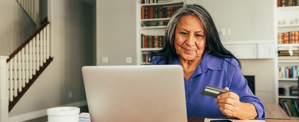 Une femme d'affaires professionnelle est assise à son bureau, interagissant activement avec des technologies avancées sur son ordinateur portable.