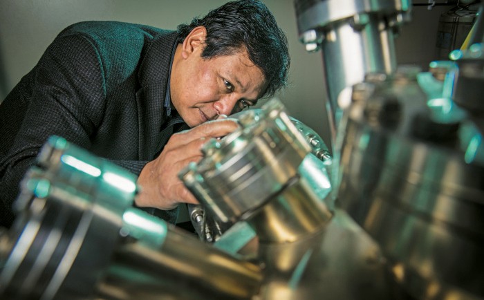 A photo shows Hla peering into an STM chamber.