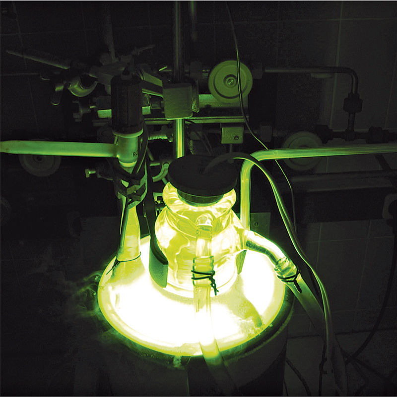 A chemical apparatus glows green.