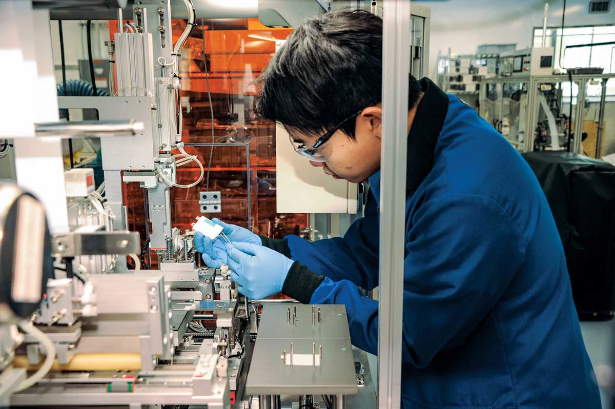 This photo shows a scientist at Argonne National Laboratory preparing pouch-type Li-ion batteries to study battery recycling.