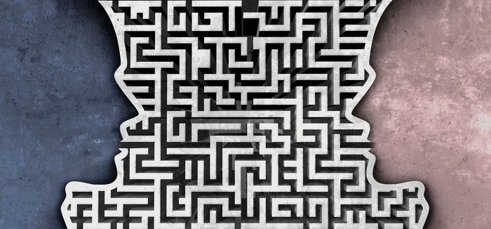 Decorative art featuring a maze design out of which two heads in profile face each other.