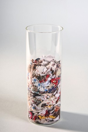 A glass tube with finely shredded polyester garments.