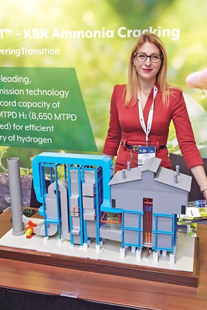 KBR engineer Elena Stylianou with a tabletop model of a plant that uses KBR's ammonia-cracking process.