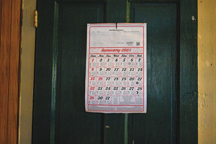 A calendar hanging on a door shows January 2023. 