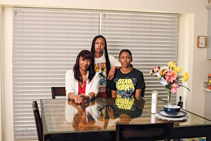 Woman with her two children seated by a table.