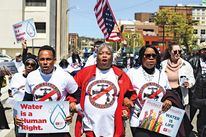 People marching with placards saying “Water is a human right” and “Water is life”.