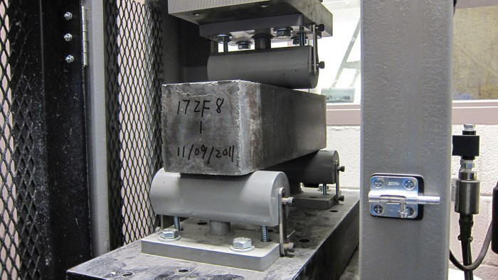 Concrete beam being tested in a machine.