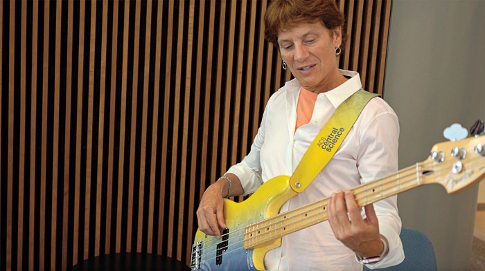 Carolyn Bertozzi holding a bass guitar.