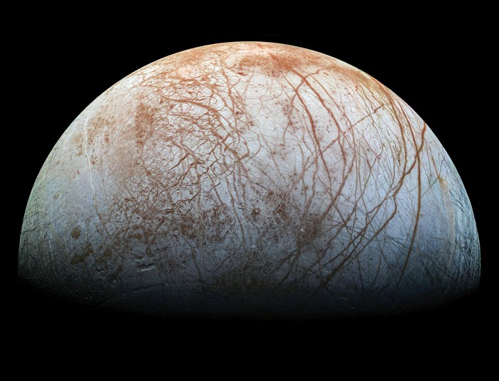 Europa showing a white- and red-mottled surface covered in dark red scratches.