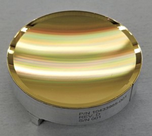 Eine konkave goldene Platte erscheint aufgrund des von ihrer Oberfläche reflektierten Lichts farbgestreift.