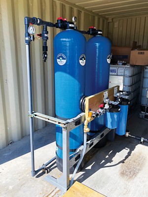 Two water filtration tanks containing plant-based sorbents in a trailer deployed at a former military base.