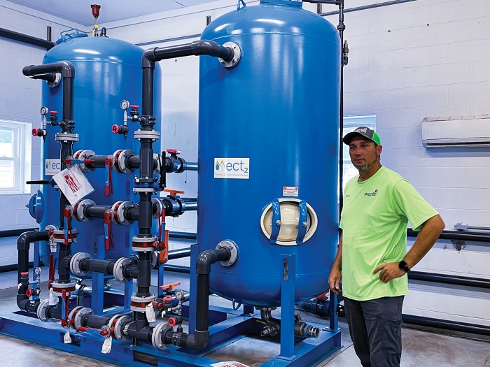 A worker stands beside two water filtration systems at a drinking-water plant in Maysville, North Carolina.