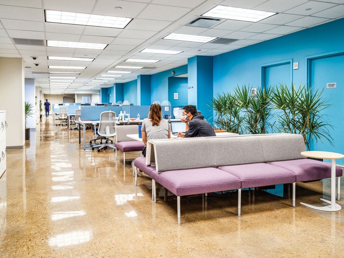 Two people meet in the coworking office space of BioLabs at NYU Langone.  
