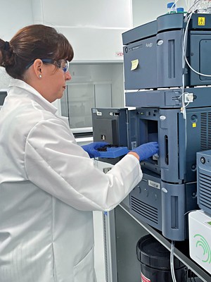 A scientist loads samples into an ultra-performance liquid chromatography instrument.