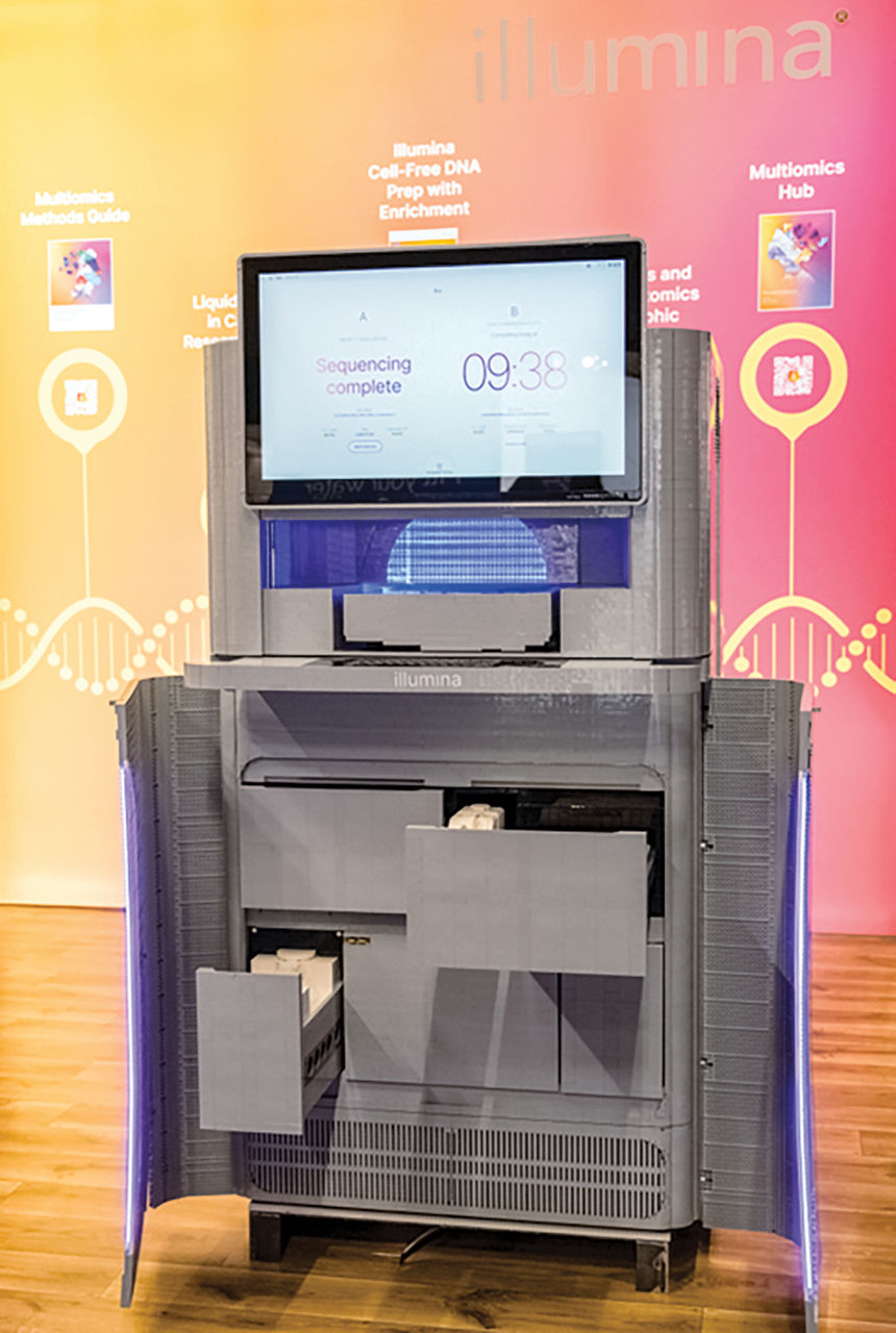 A gray refigerator-size Lego model of one of Illumina's NovaSeq X high-throughput sequencers is displayed at a conference.