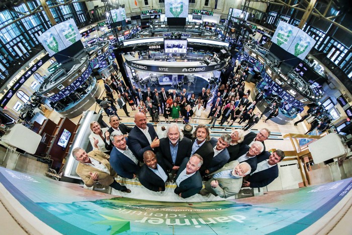Executives looking up from the balcony of the New York Stock Exchange.