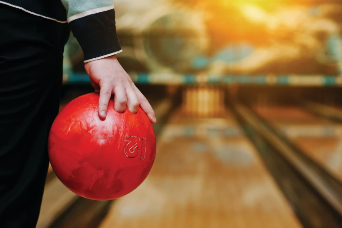This is an image of a person holding a bowling ball at the far end of a lane.