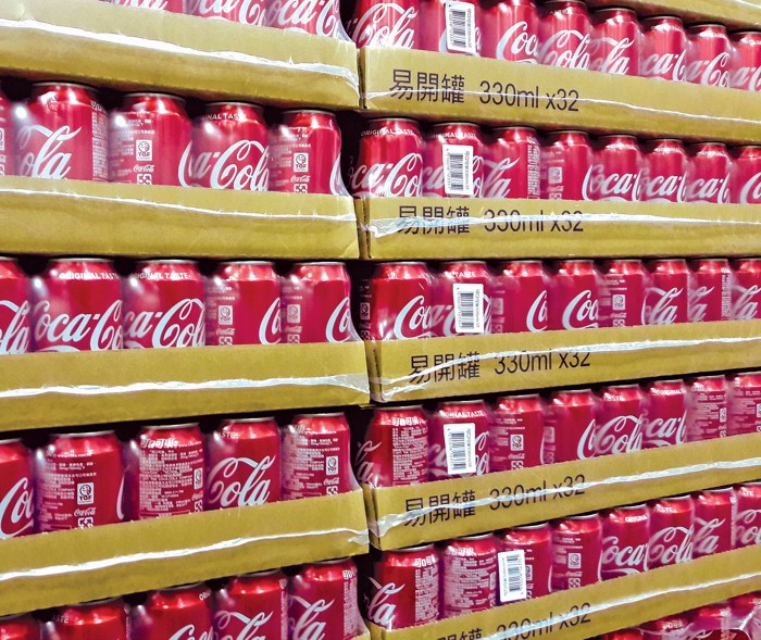 A photo of a stack of CocaCola cases with Chinese writing on the cardboard.