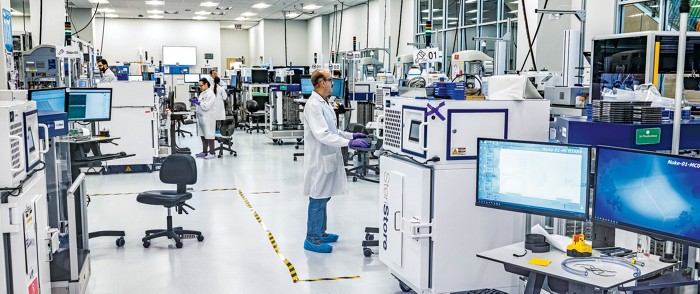 Researchers in a wide-open lab with a lot of equipment.
