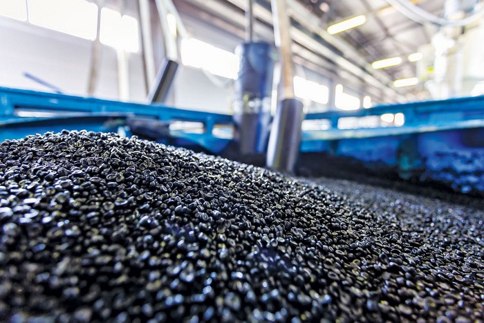 Black plastic pellets in a large container.