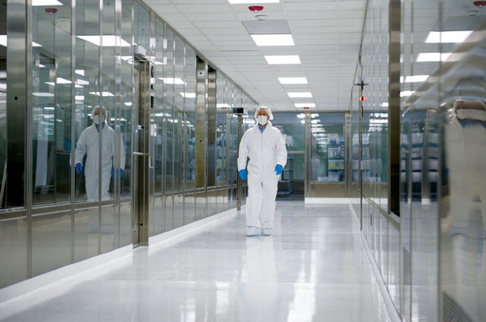 A laboratory technician walks in a radiopharmaceutical manufacturing plant.