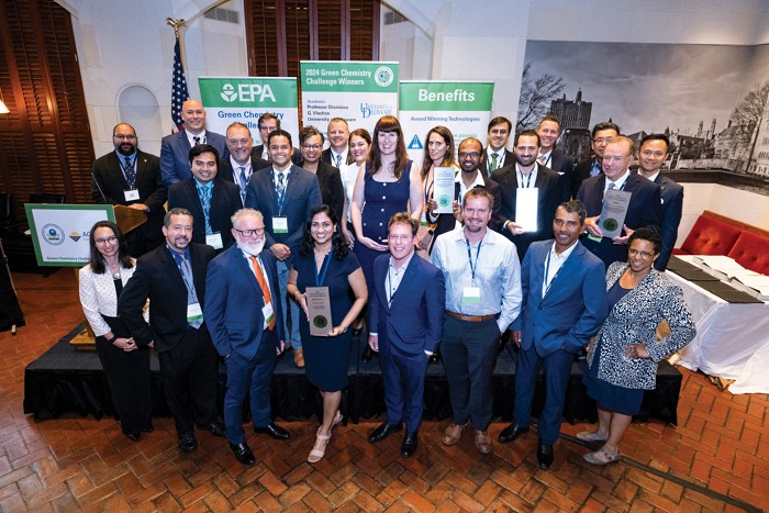 A group of people stand together holding awards.
