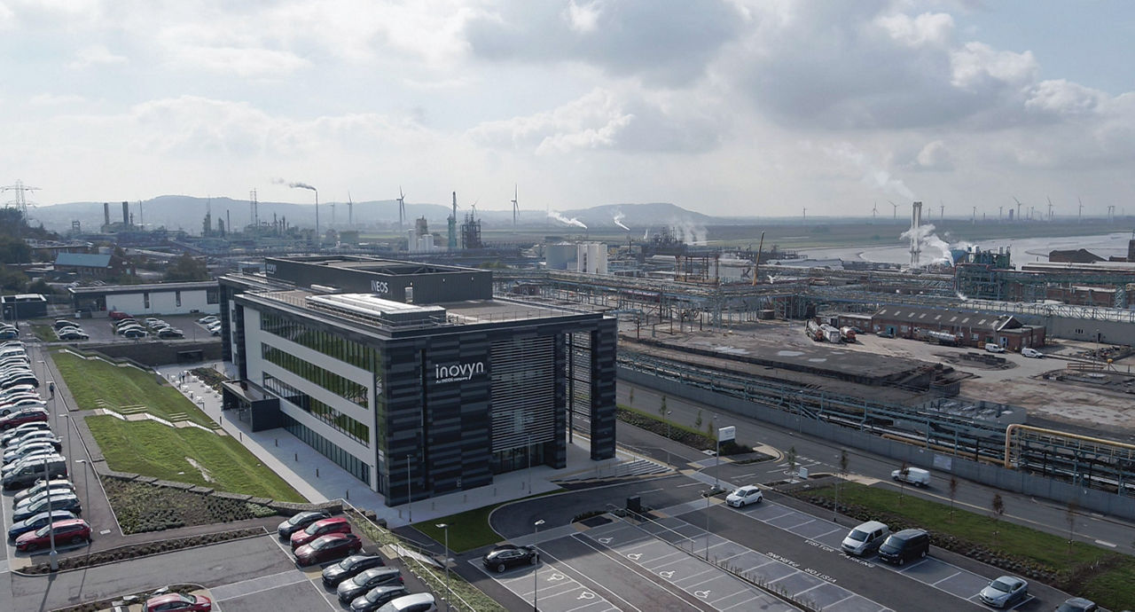 A manufacturing site with a petrochemical plant in the background and an office building in the foreground with a sign labeled “Inovyn.”