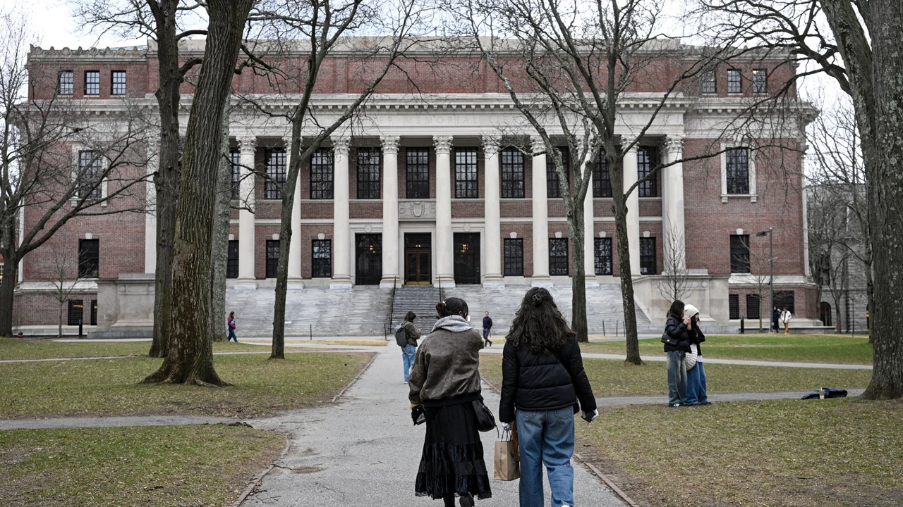 People walk in front of a columned building.