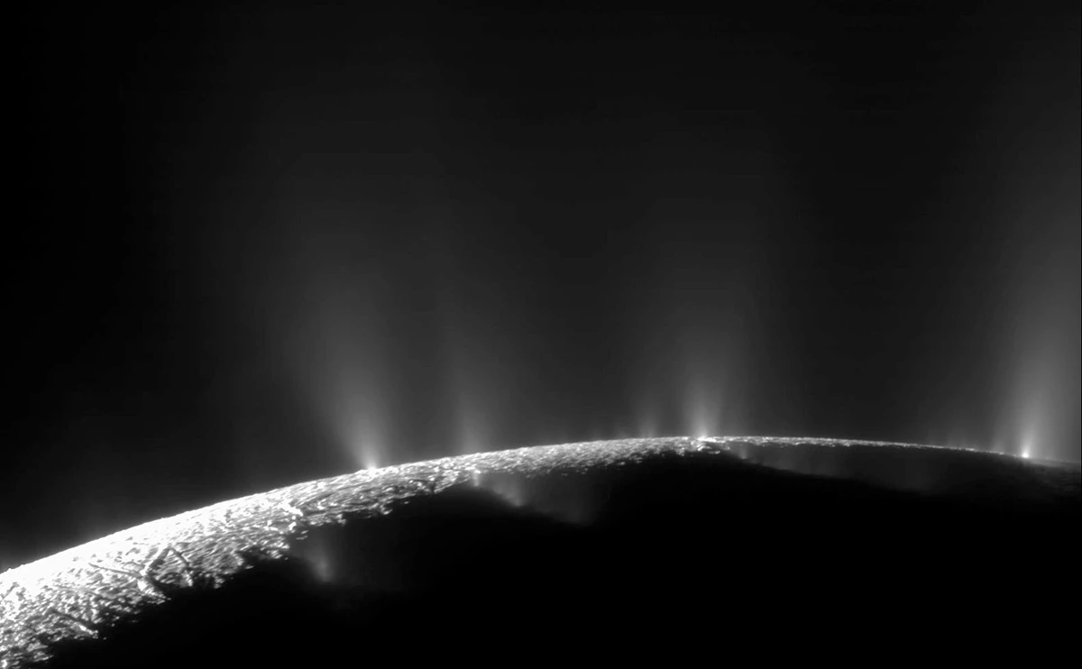 An image of Enceladus’s edge with its geysers visible against the blackness of space.