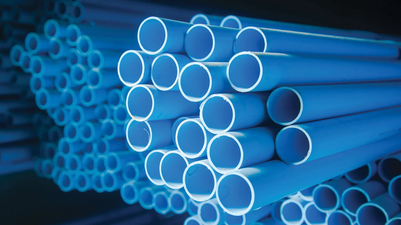 Large blue plastic pipes are stacked on top of each other.
