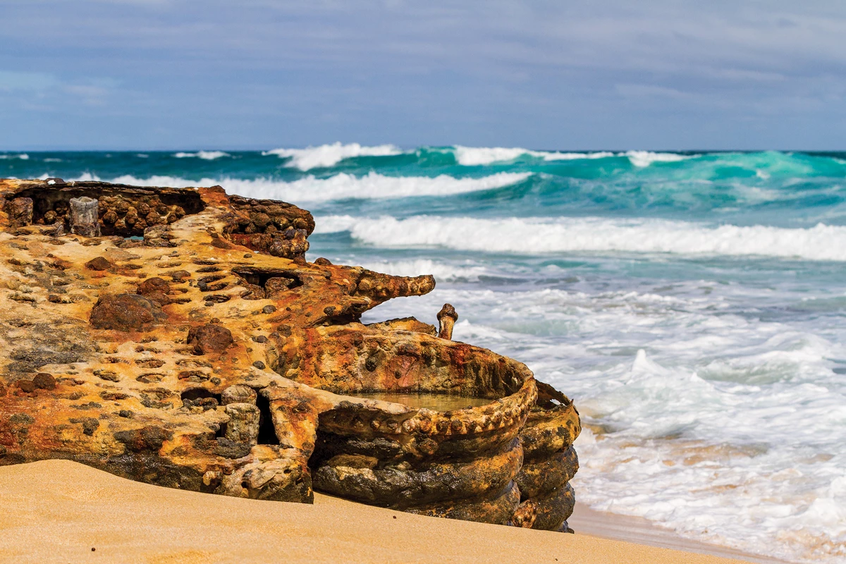 A wide-angle landscape photo of a rocky beach on a cloudy day in southern Australia.
