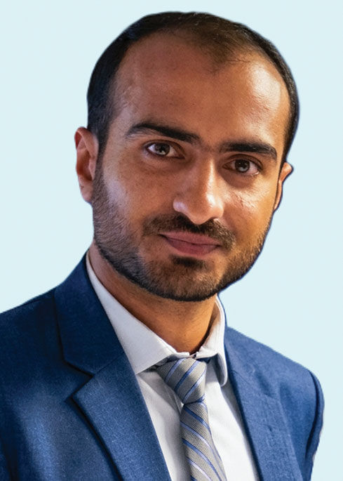 Abdul Rehman, wearing a blue suit jacket and a tie with gray, blue, and lavender stripes, poses for a portrait.