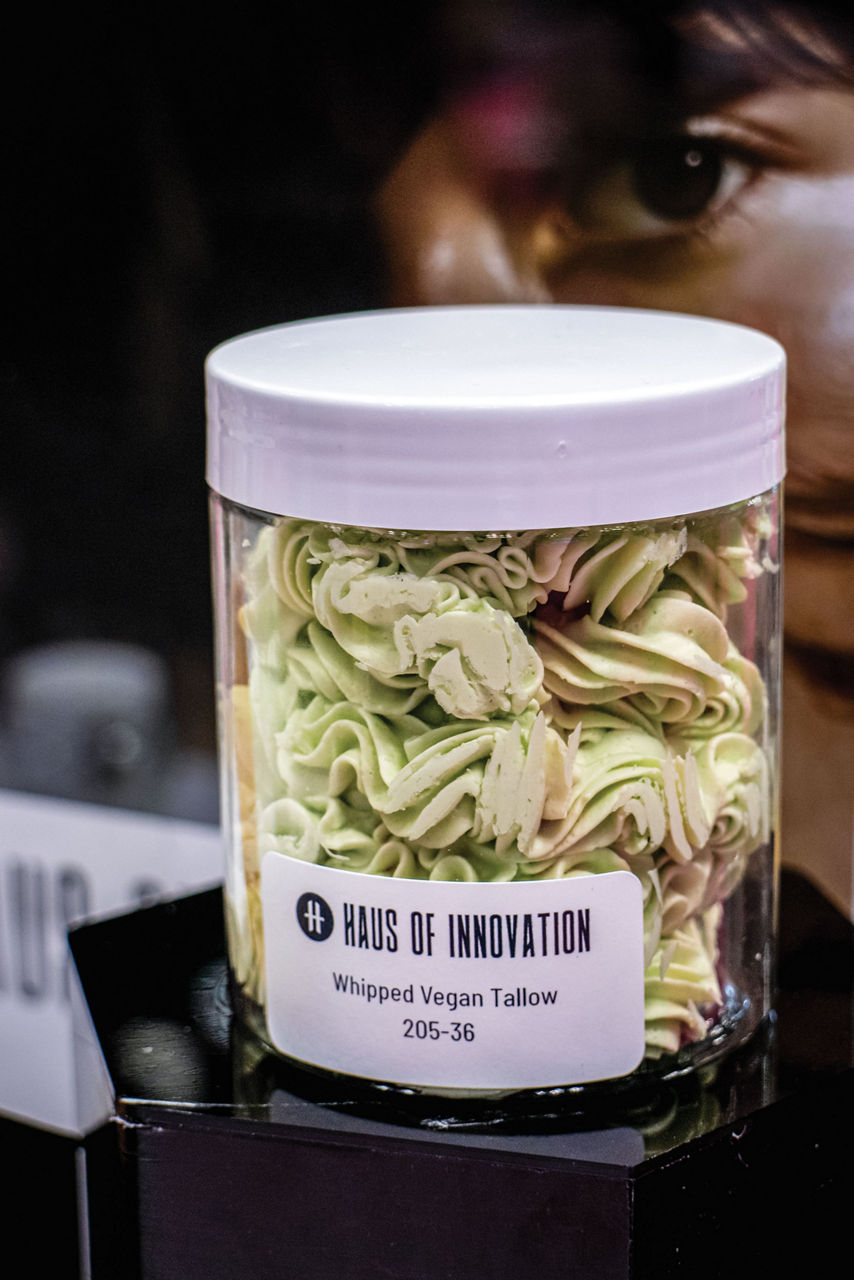 A jar is filled with a stiff but creamy beige substance. The label says it is whipped vegan tallow.