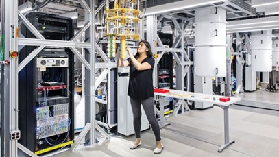 A scientist adjusts some equipment in a computer lab.