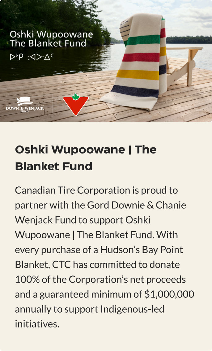 Hudson's Bay Point Blanket is draped on a Muskoka chair highlighting the Oshki Wupoowane Blanket Fund charity.