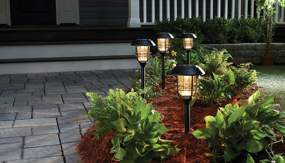 A hanging wicker solar light in a backyard patio.