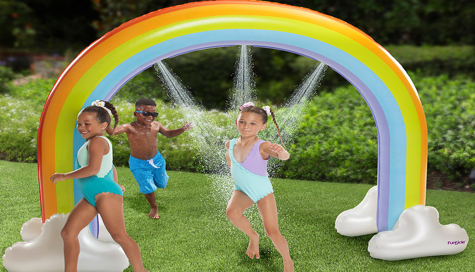 Kids playing outside on a backyard water slide.