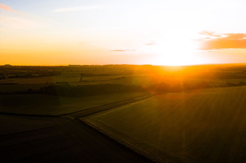 Sun rising over a green valley