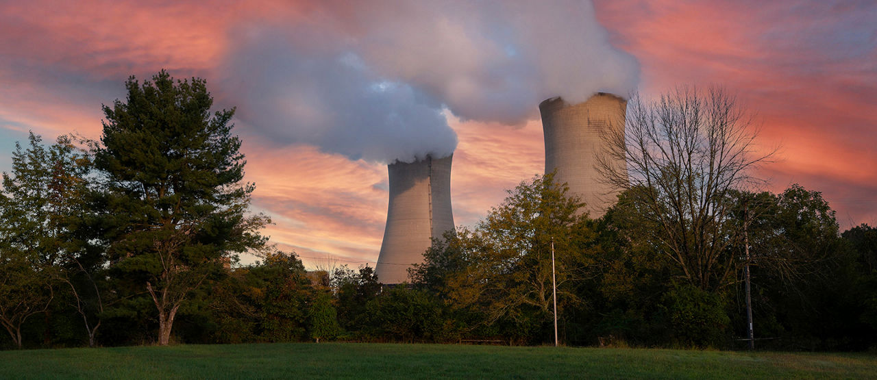 Nuclear cooling towers in front of sky at sunset